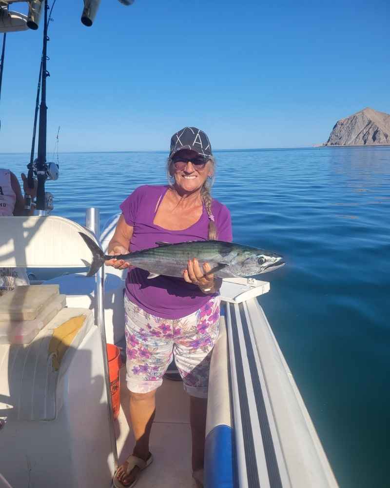 Guest holding up a fish from a local fishing trip